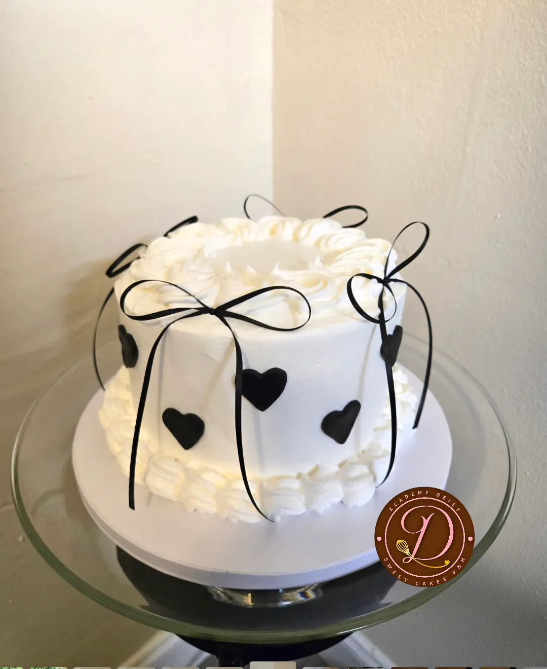 Cake blanco minimalista con lazos negros y corazones de fondant