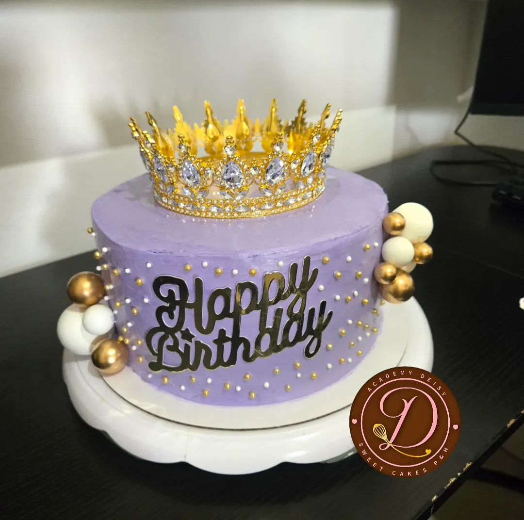 Cake lila decorado con perlas doradas, esferas y corona de pedrería
